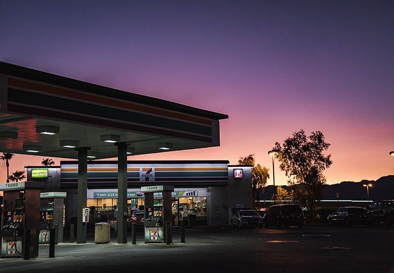 An empty gas station with a convenience store during sunset.