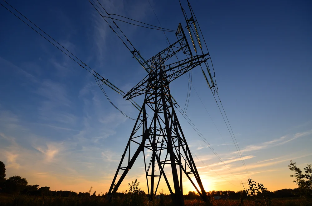 Una torre de la red eléctrica al atardecer.