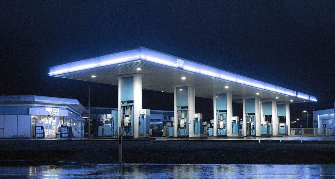 An empty and lit modern petrol station at night. 