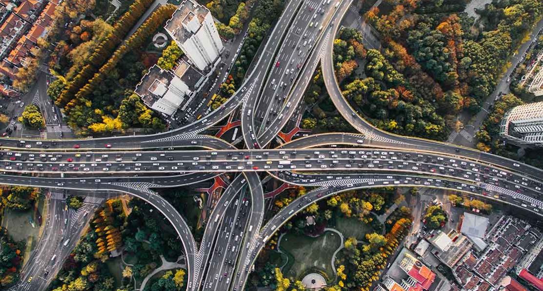 An aerial shot of an intersection of roads in a busy urban environment.