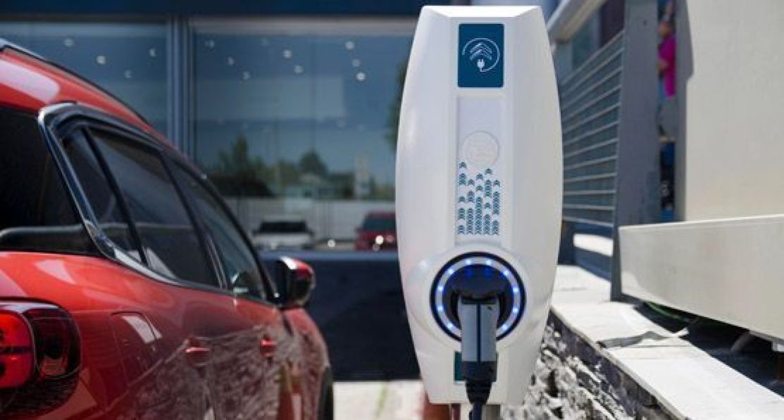 EVBox BusinessLine charging station next to an electric car