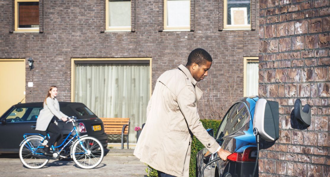 A man charging his car at home.