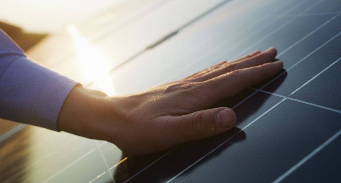A hand on a solar panel