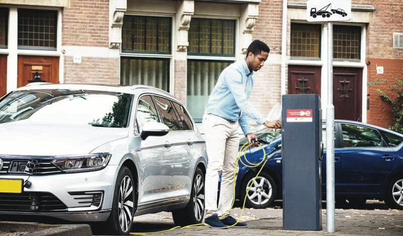 Hombre cargando coche eléctrico en Amsterdam
