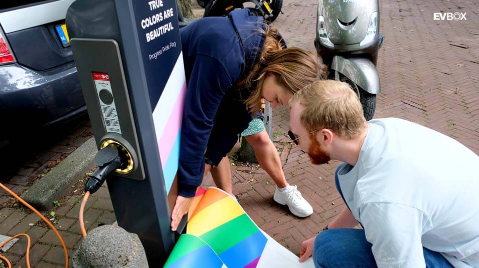 Menschen kleben Regenbogenaufkleber auf Ladestationen