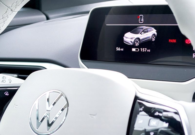 På instrumentpanelen i en elektrisk Volkswagenbil visas att bilen är parkerad, att vänster framdörr är öppen, att resan var 56 mil och att det beräknade avståndet till tomkörning är 157 mil.