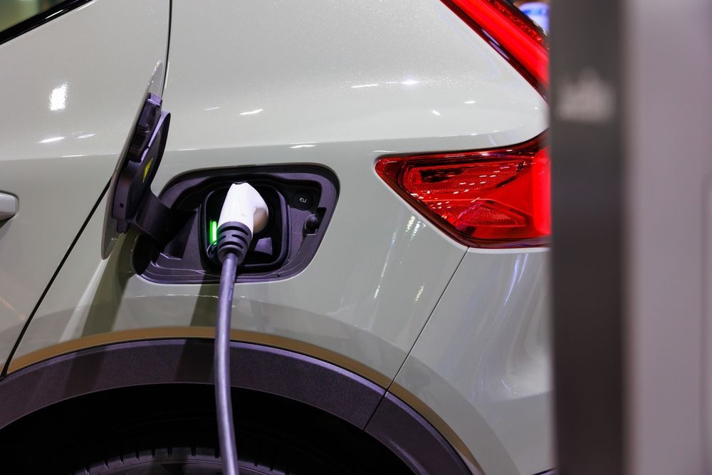 A closeup of a plugged in EV while charging.