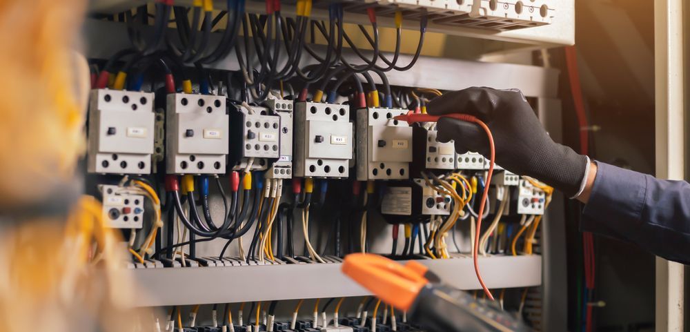 En installatør som jobber forsiktig i et strømskap