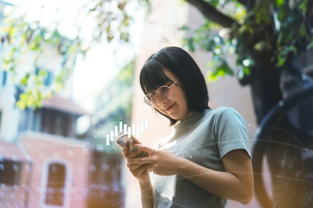 Eine lächelnde Frau, die auf ihr Smartphone schaut, und eine gestaltete Visualisierung von Daten, die die Möglichkeiten der Konnektivität und der Einblicke hervorhebt.