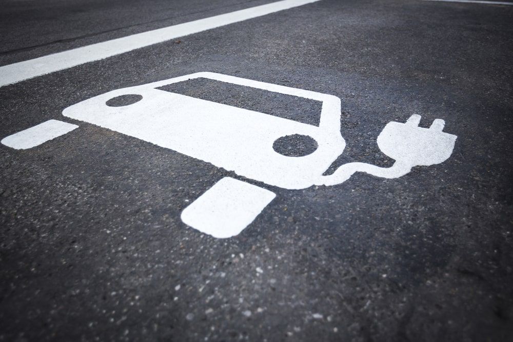 Electric car charging sign on asphalt.