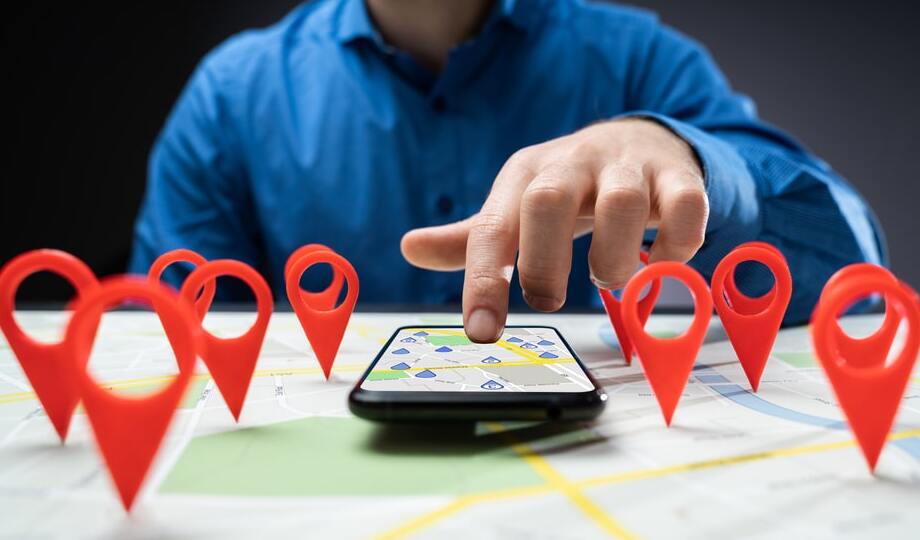 A physical map with red pins and a smartphone with a map app opened to represent online findability.