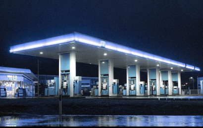 An empty and lit modern petrol station at night.