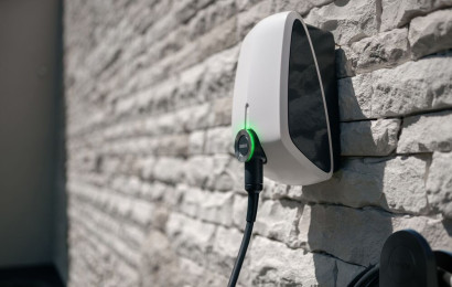 An Elvi home charging station is mounted on a brick wall.