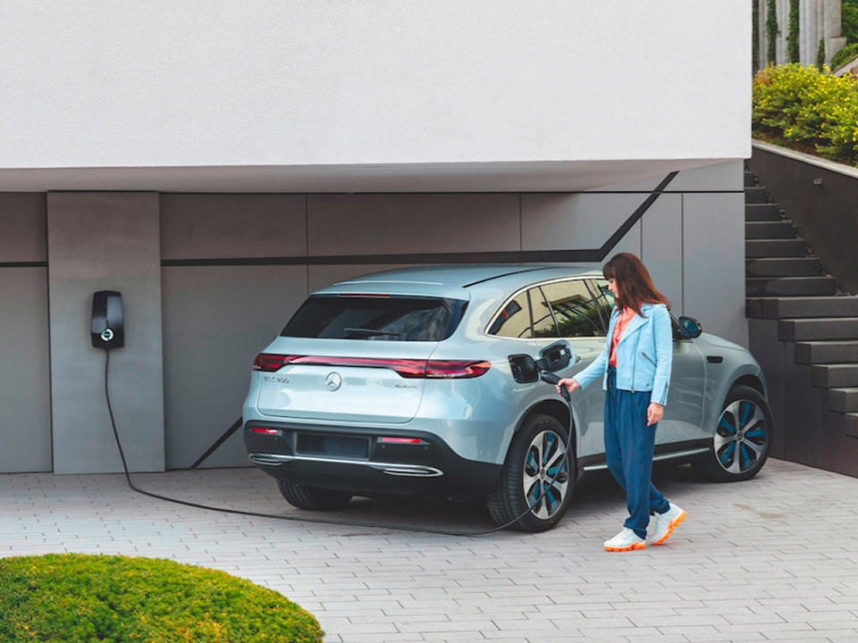 Woman charging her Mercedes Benz with an EVBox charging station