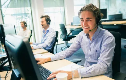 three people sitting in an office and talking to each other