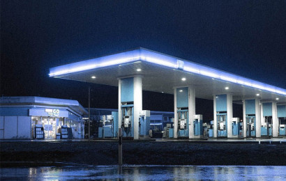 En tom og opplyst moderne bensinstasjon om natten.
