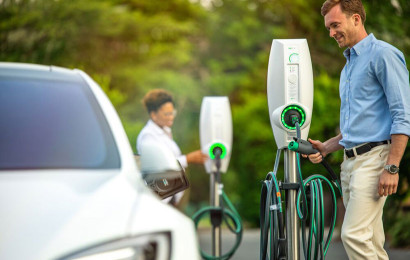 Un homme et une femme utilisant les bornes de recharge EVBox BusinessLine pour recharger leurs véhicules électriques