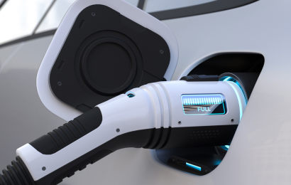 An electric vehicle being charged with a futuristic looking charging port which indicates the vehicle is full in LED lights.