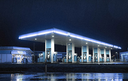 Front view of a gas station lit up at night