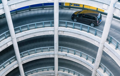 Een cirkelvormige parkeerplaats met meerdere verdiepingen waar een auto op rijdt