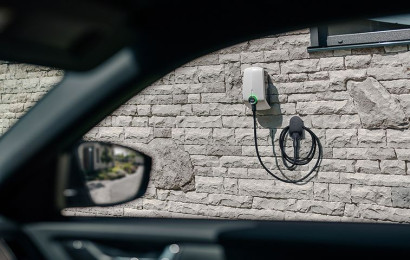 An Elvi home charging station mounted on the wall is seen by the window of the electric car.