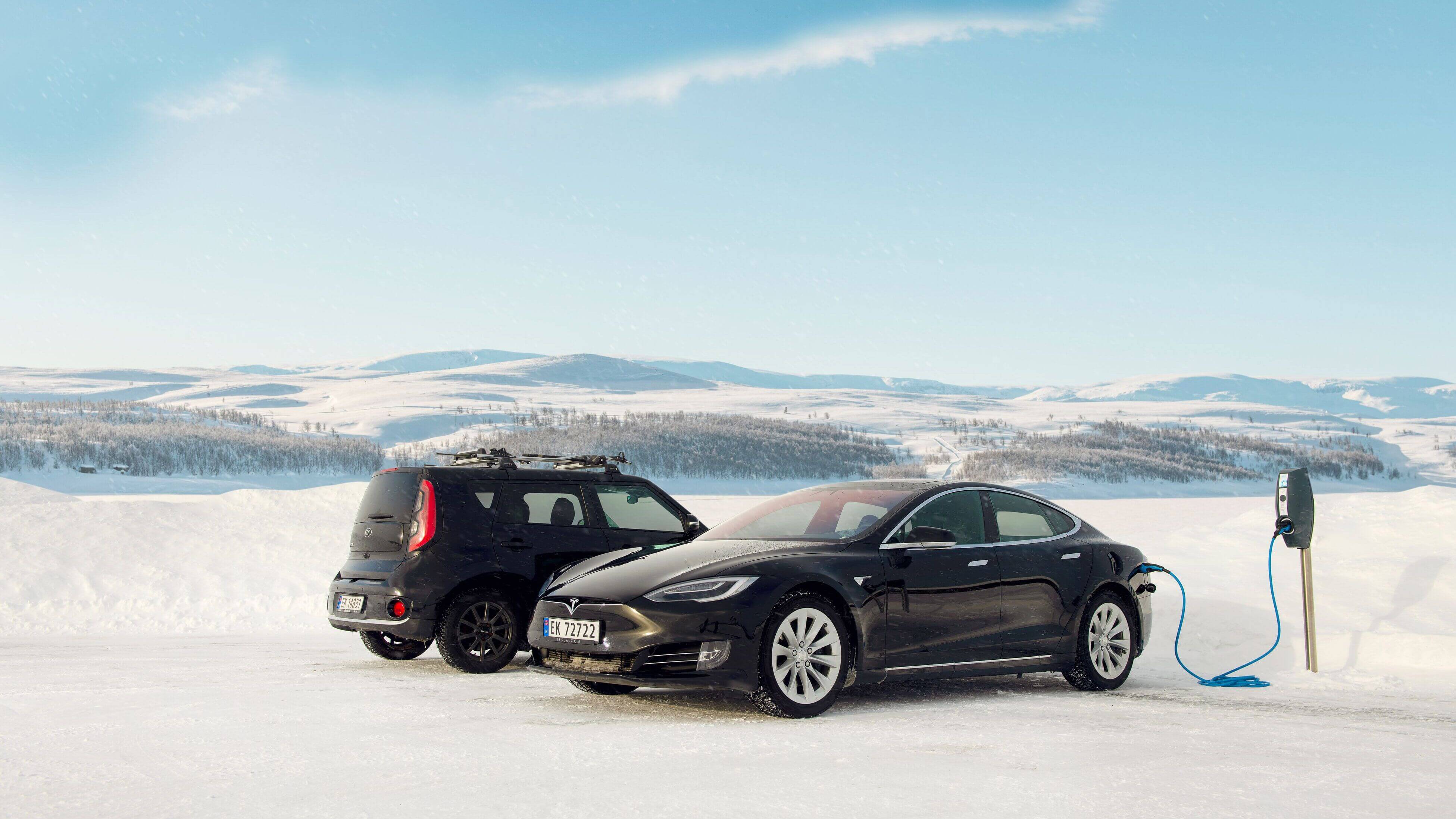 An EVBox BuisnessLine next to two cars in the snow in Norway